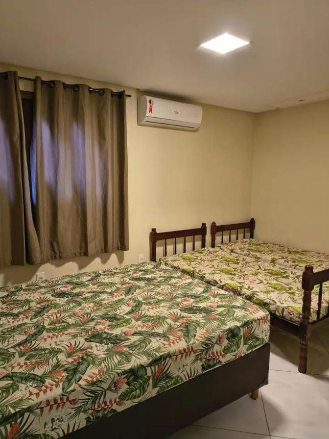 Quarto com cama de casal, cama de solteiro e ar-condicionado